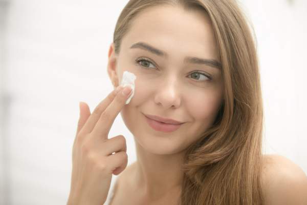 Putting cream on face