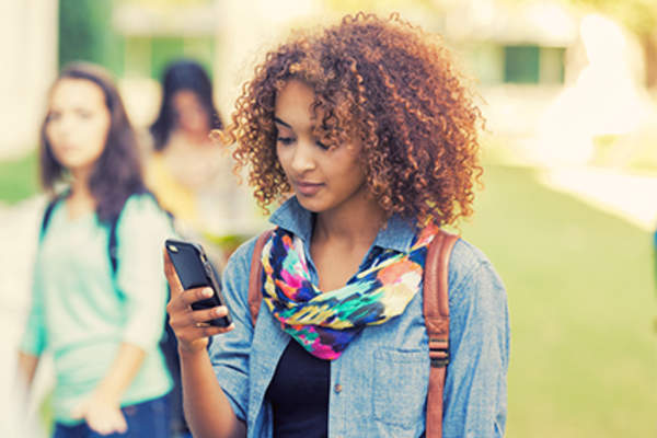 Pretty young black woman using smartphone.