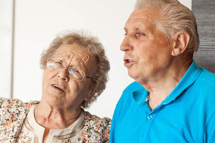 Senior man and woman singing.