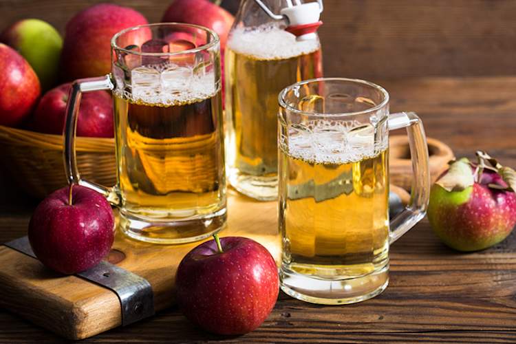 Apples and glasses of hard apple cider.