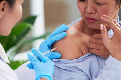 Doctor administering a vaccine to a patient with rheumatoid arthritis.