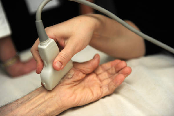 Tech performing a hand ultrasound.