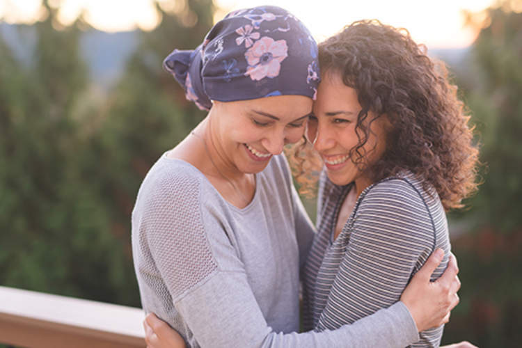 Woman hugging a friend with cancer.