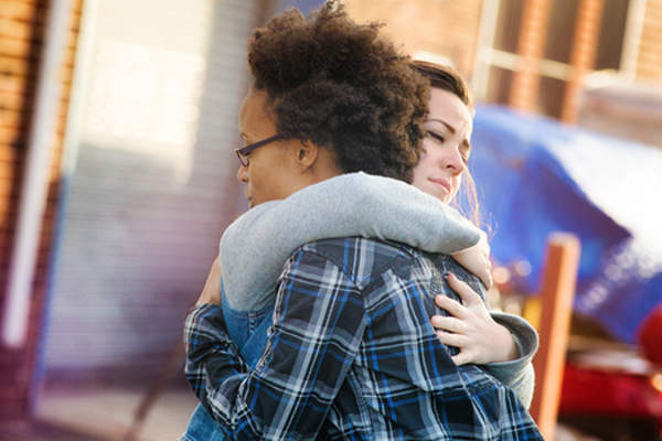 Friends hugging, forgiving.