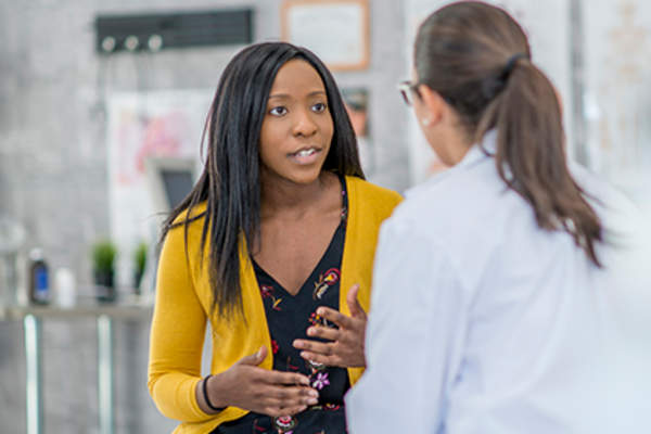 Young woman talking to her doctor about her condition.
