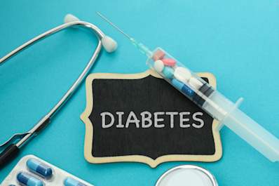 Diabetes tag with syringe, pills, and stethoscope.