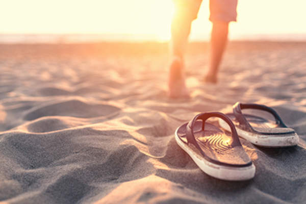 Walking barefoot in the sand.