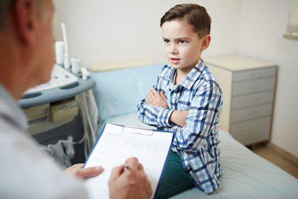 Doctor talking to angry child.