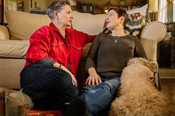 Adult couple enjoying intimacy sitting at home with their dog.