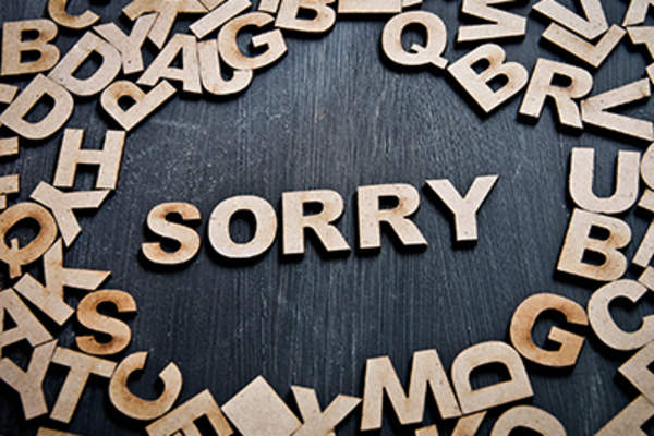 Sorry spelled out in wooden letters.