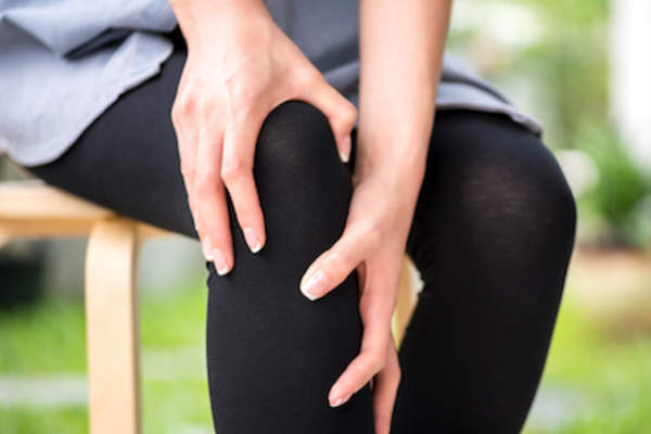 woman rubbing inflamed knee.