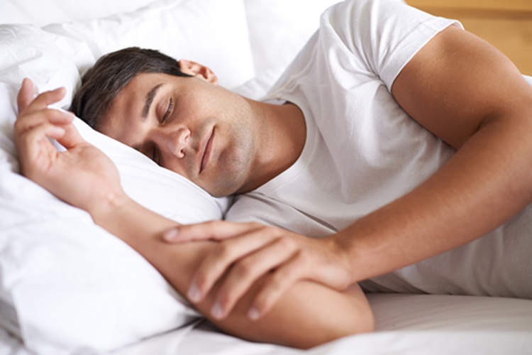 Man sleeping happily in bed.