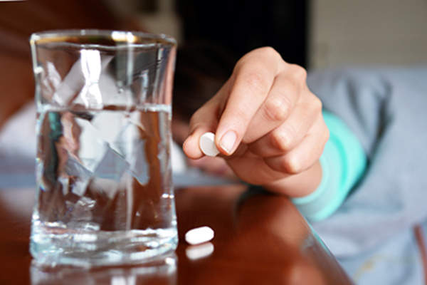 Woman using a melatonin supplement to fall asleep.
