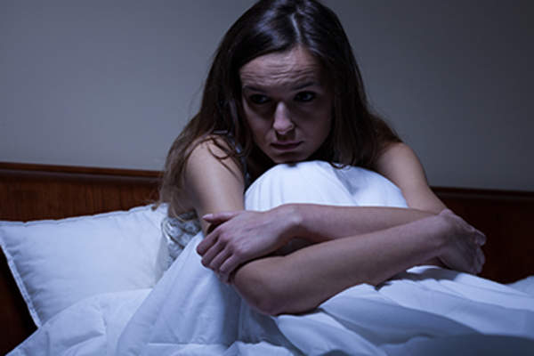 Woman awake in bed at night.