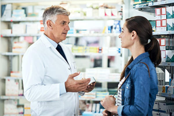 Woman talking to pharmacist.