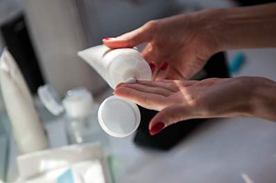 Applying moisturizer to prevent a psoriasis flare.