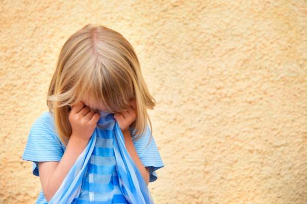 child covering her face with shirt
