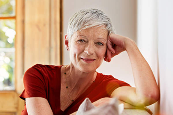 Senior woman happy and smiling at home on couch.