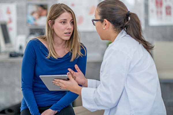 Patient discussing symptoms with her doctor.
