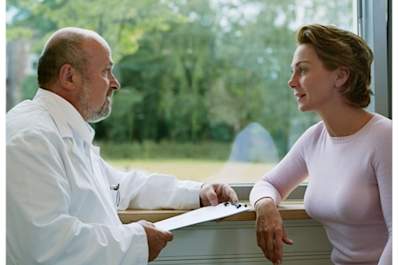 Woman talking to doctor in front of window