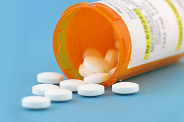 Pills spilling out of pill bottle.