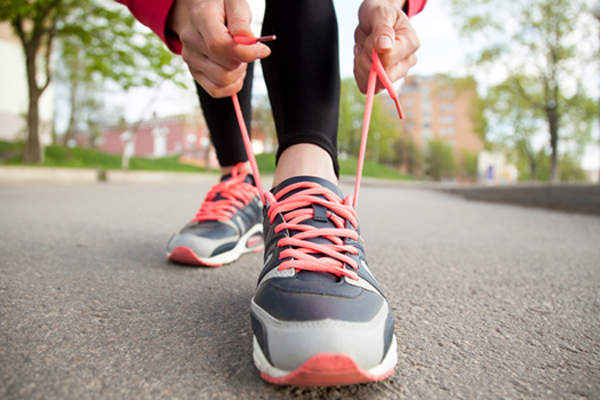 Woman tying sneakers.