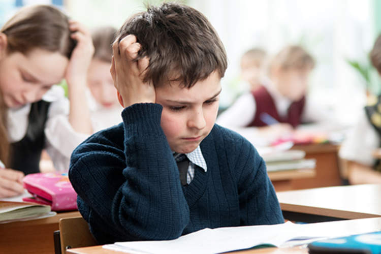 Boy with a migraine struggling at school.