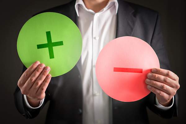 Man holding positive and negative symbols.