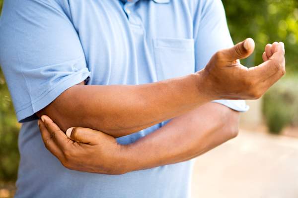 Man holding painful, sore elbow.