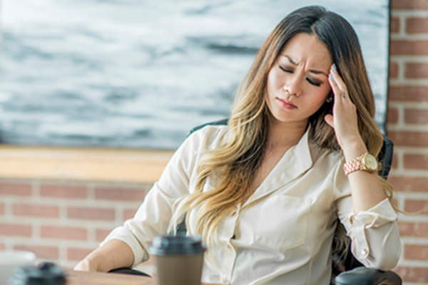 Woman with a migraine at work.