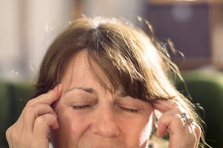 Woman having migraine with aura.