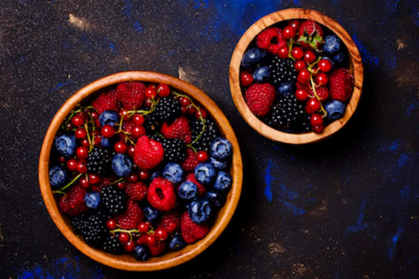 Dark berries in wood bowls.