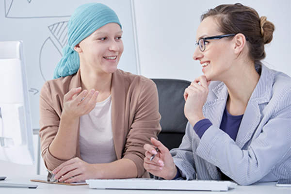 Woman discussing cancer treatment side effects with her doctor.