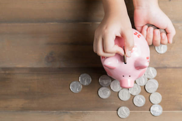 Saving in a piggy bank, saving concept.