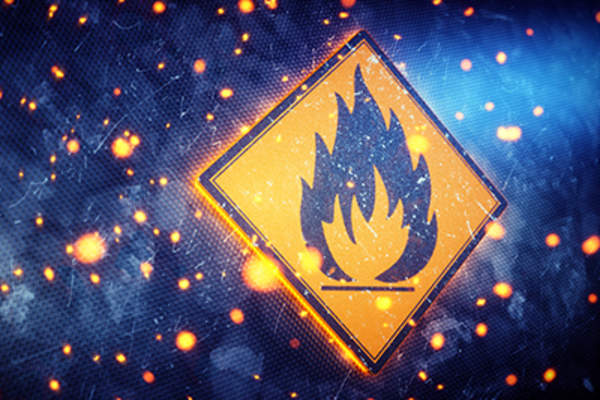 Fire warning sign and burning embers symbolizing inflammation.