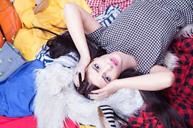 woman lying on pile of clothes.