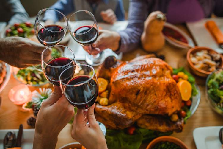 Cheers with wine glasses during a holiday meal.