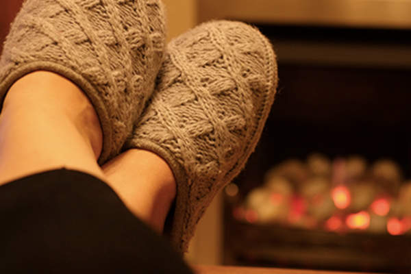 Wearing slipper in front of the fireplace.