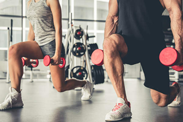 Man and woman lifting weights at the gym.