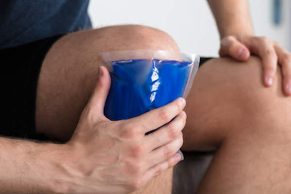 Sitting icing knee.