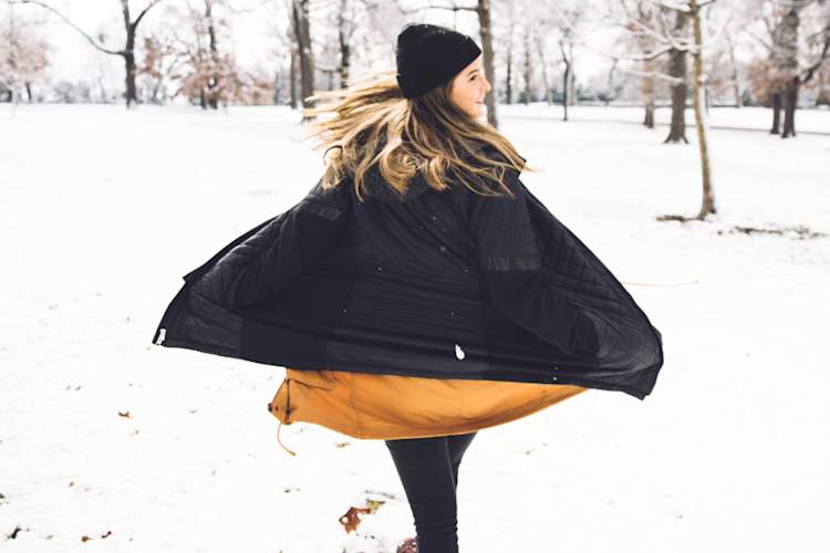 woman wearing black and yellow in the snow