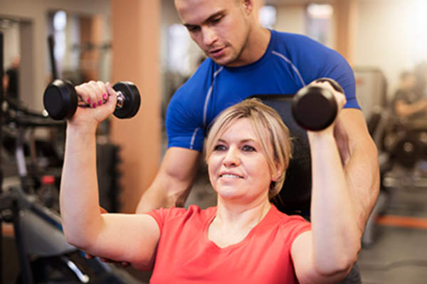Woman strength training with a personal trainer.