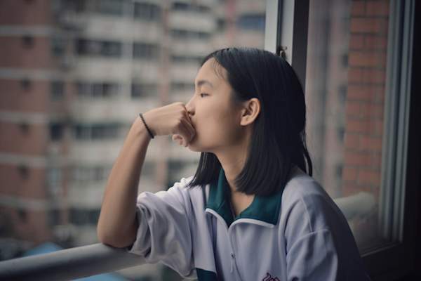 woman looking out window, thinking