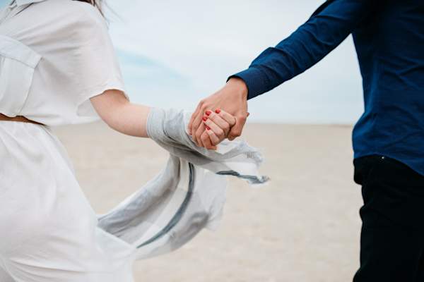 couple holding hands on the beach