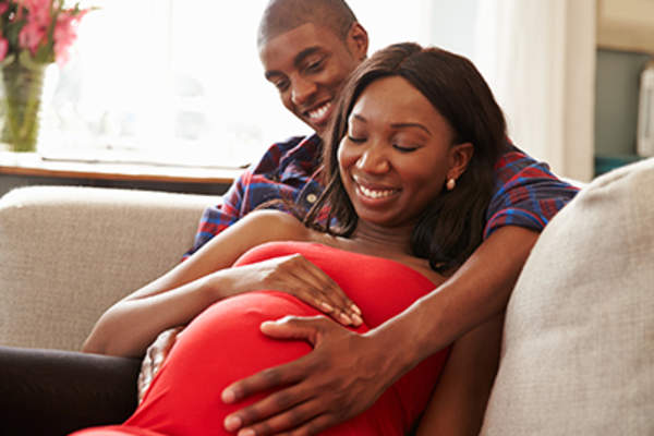 Pregnant couple lying on the couch.