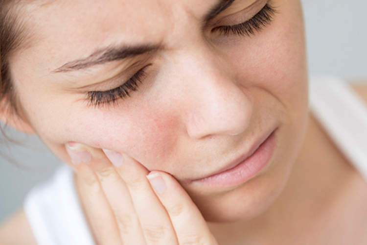 Woman with sharp pain in face.
