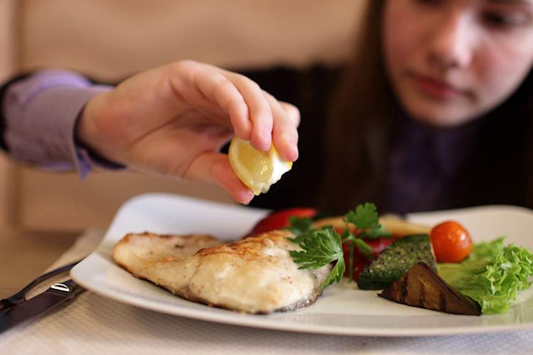 Girl having fish for dinner.