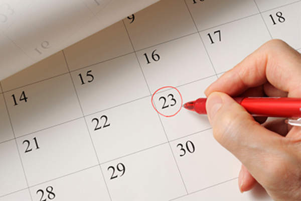 Woman circling a date on the calendar.