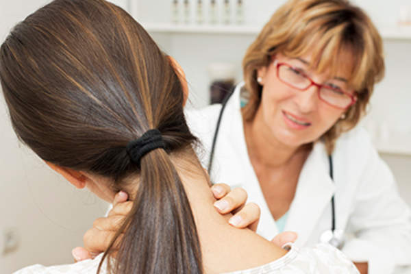 Doctor examining a woman's thyroid.