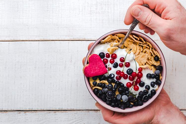 close up of man's hands eating yogurt